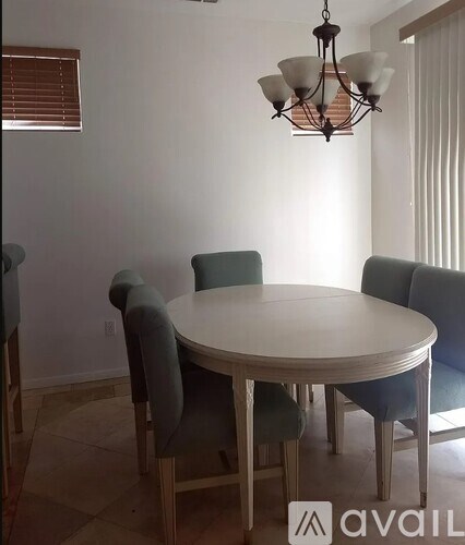 A dining room with a round table and chairs.