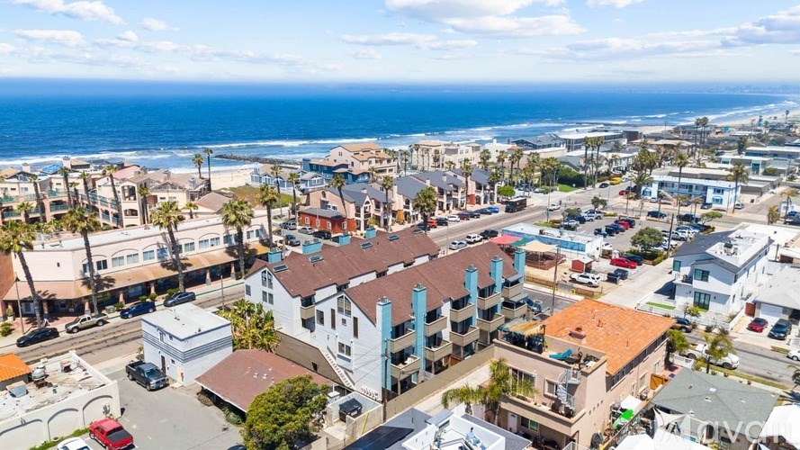 A coastal town with apartment buildings and a view of the ocean.