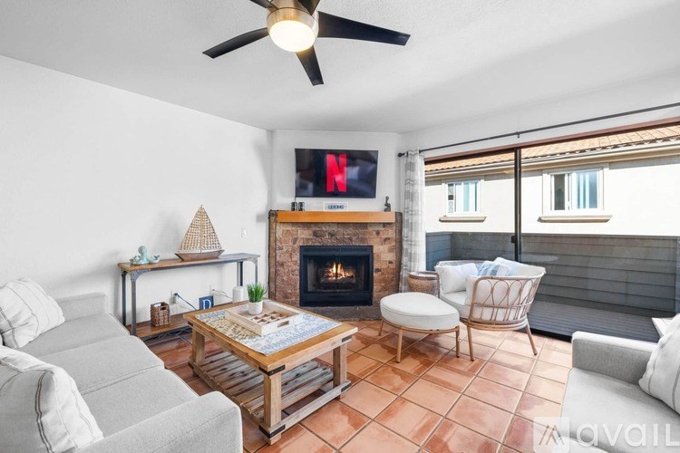A living room with a fireplace and a TV mounted above it.