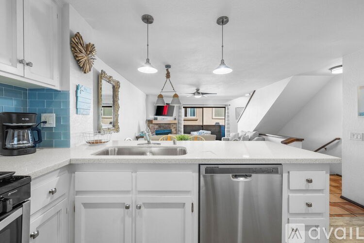 A kitchen with white cabinets and a blue tile backsplash.