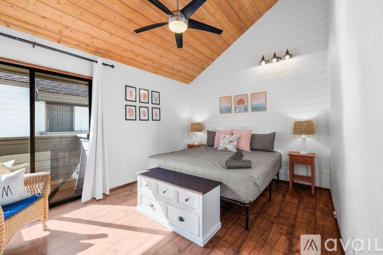 A bedroom with a bed, nightstand, and a ceiling fan.