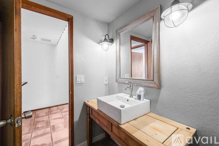 A bathroom with a wooden vanity and a mirror above it.