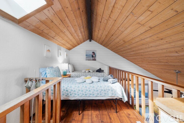 A bedroom with a bed and a skylight.