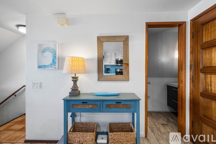 A blue desk with a lamp and a mirror above it.