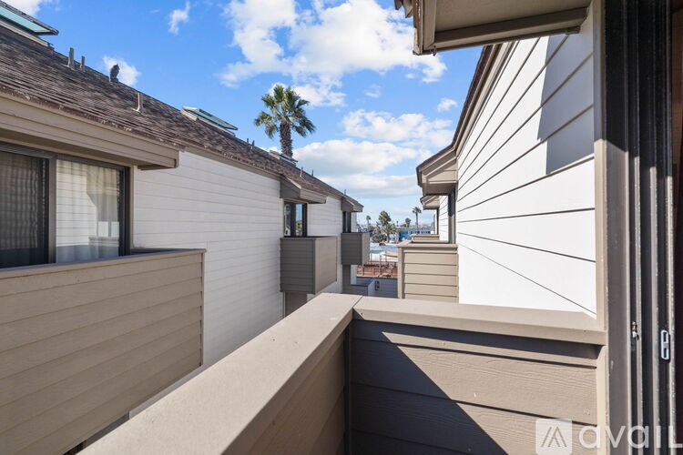A balcony with a view of a palm tree and other buildings.
