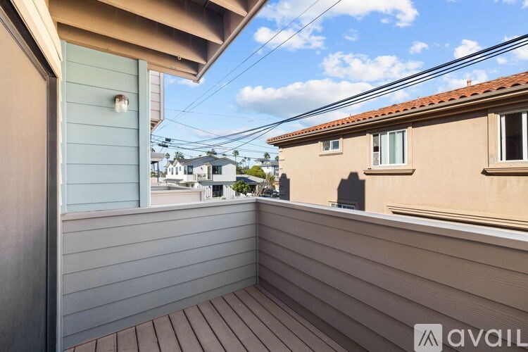 A balcony with a wooden floor and a view of other houses.
