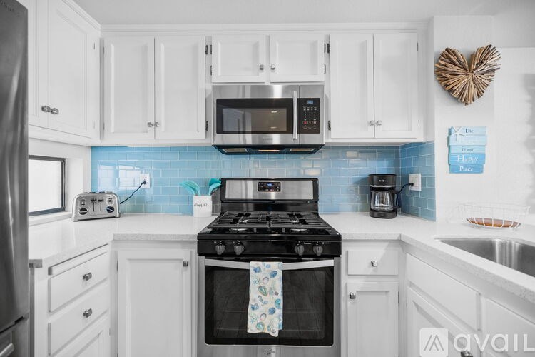 A kitchen with white cabinets and a black stove top.