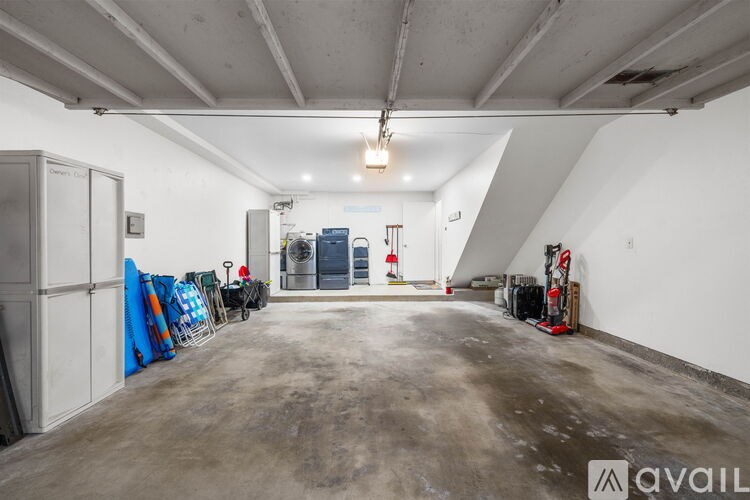 A large, empty industrial-style room with a concrete floor and white walls.