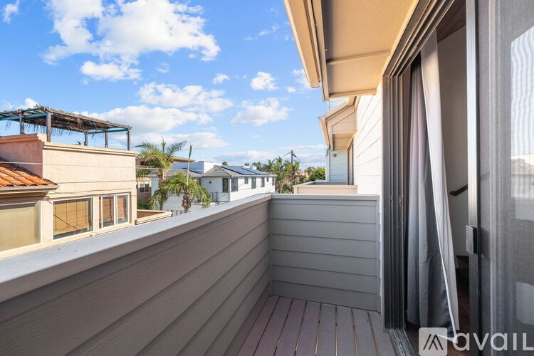 A balcony with a wooden floor and sliding glass doors.