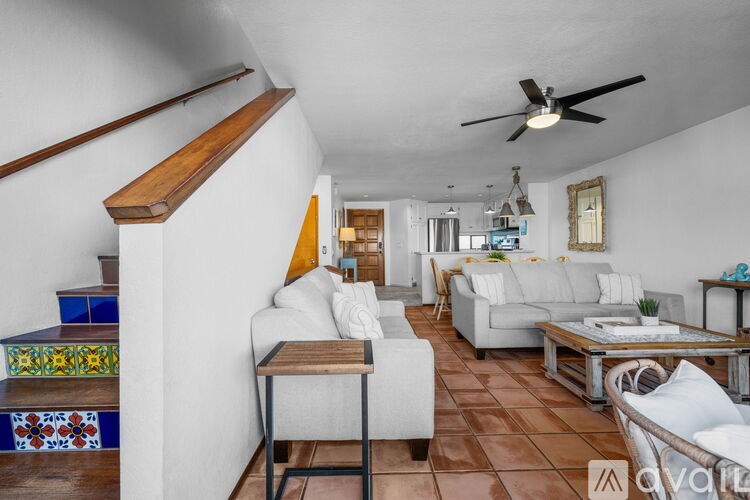 A living room with a white couch and a wooden table.