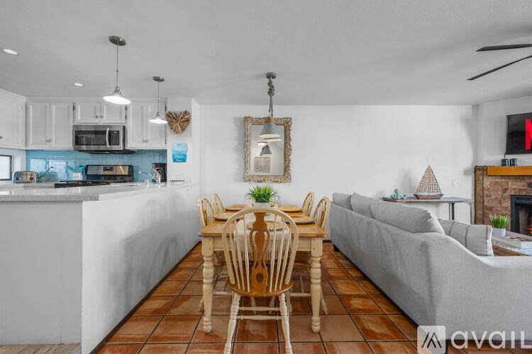 A kitchen with a dining table and chairs in the middle of the room.