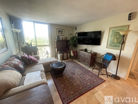 A living room with a couch, chair, and television.