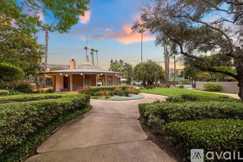 A house with a driveway and a hedge in front of it.