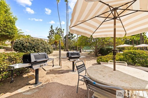 A patio with a table, chairs, and an umbrella.