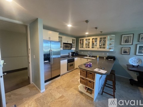 A kitchen with a refrigerator, oven, and cabinets.