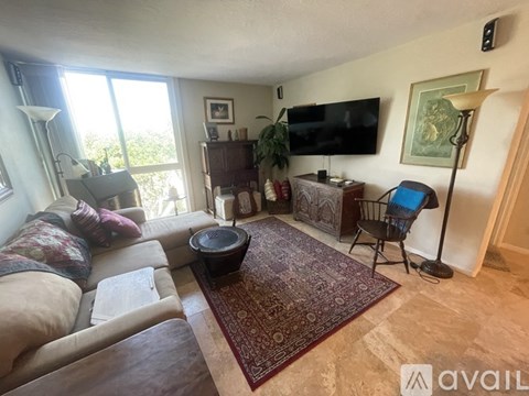 A living room with a couch, chair, and television.