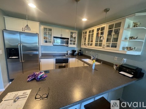 A kitchen with a granite countertop and stainless steel appliances.