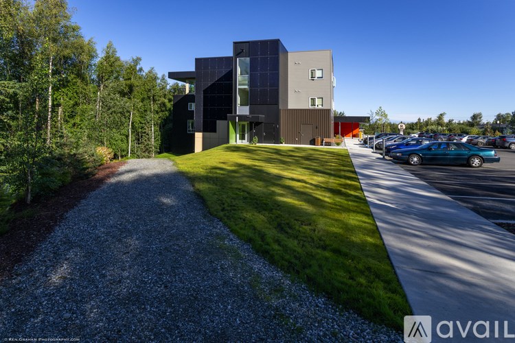 A modern building with a gravel pathway leading to it.
