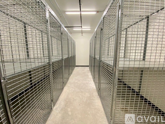 A long hallway with metal grating walls and floor.