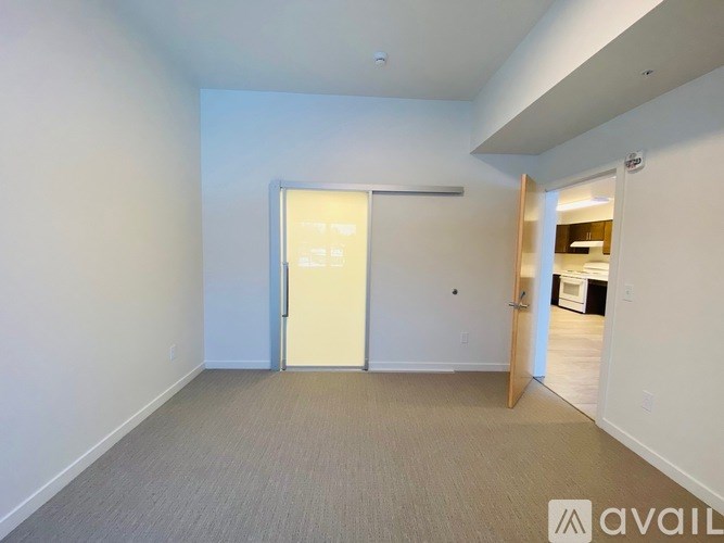 A room with a carpeted floor and a white door.