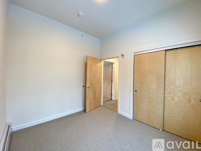 A spacious kitchen with wooden floors and white walls.