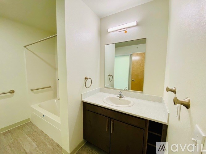 A bathroom with a sink, mirror, and bathtub.