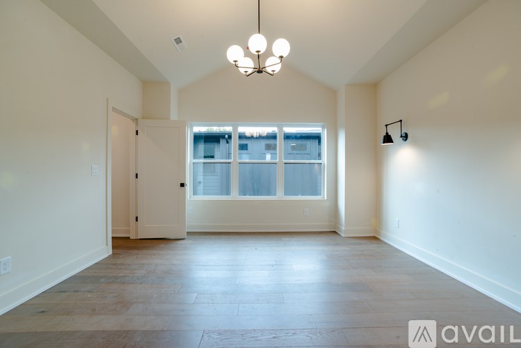 A large empty room with a door and a window.