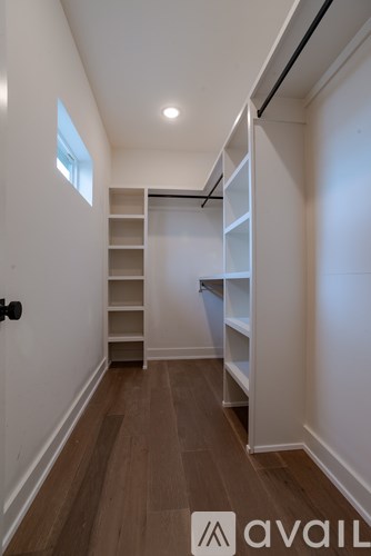 A hallway with a staircase and shelves.