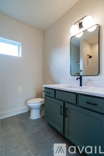 A bathroom with a toilet, sink, and mirror.