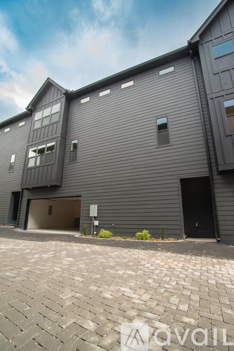 A modern building with a grey facade and a black door.