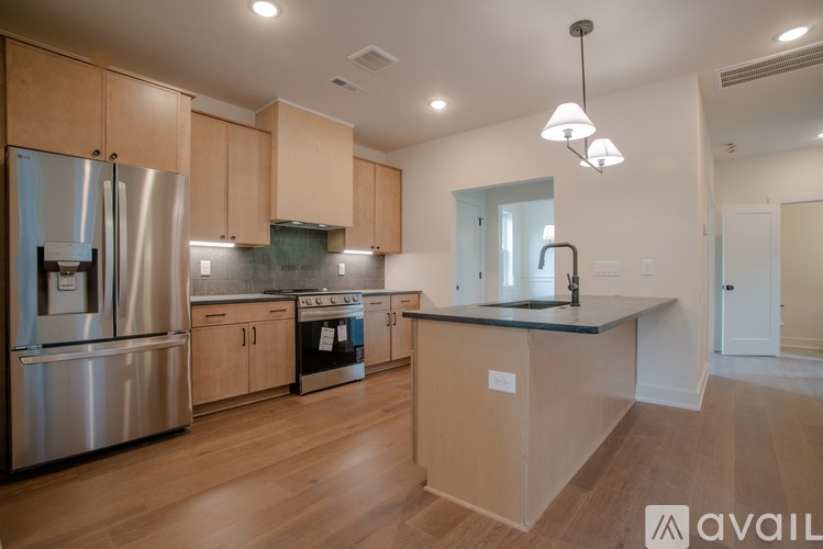 A kitchen with wooden cabinets and a stainless steel refrigerator.