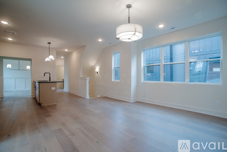 A spacious room with wooden floors and a kitchen area.