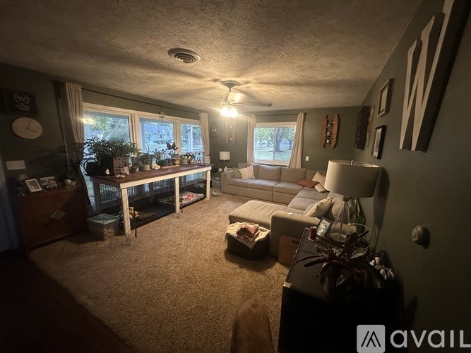 A living room with a couch, a table, and a ceiling fan.
