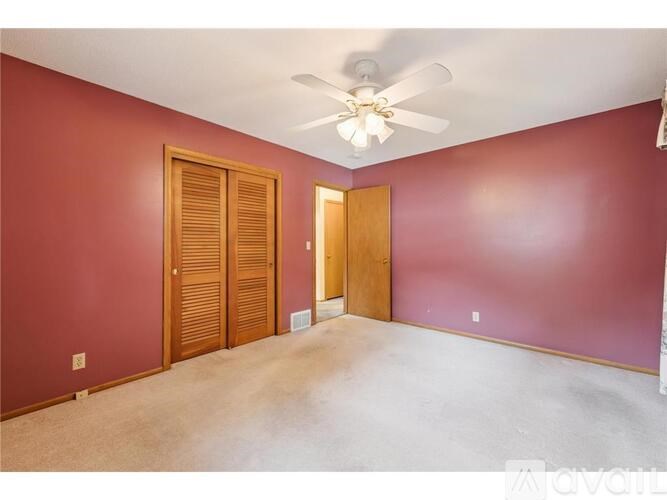 A room with a ceiling fan and two doors.