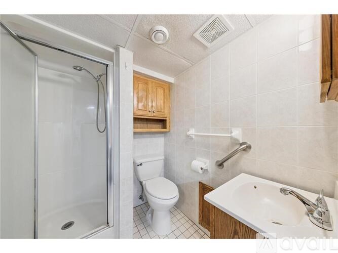 A bathroom with a toilet, sink, and shower.