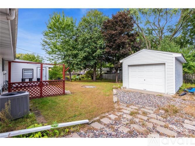 A backyard with a shed, a fence, and a grassy area.