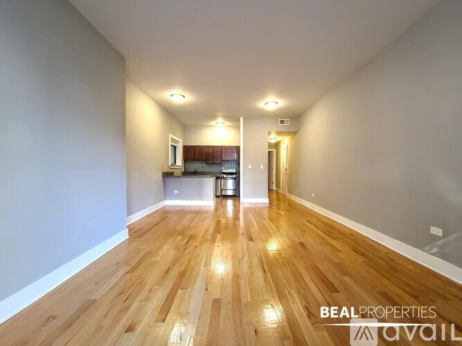 A long hallway with wooden floors and white walls.