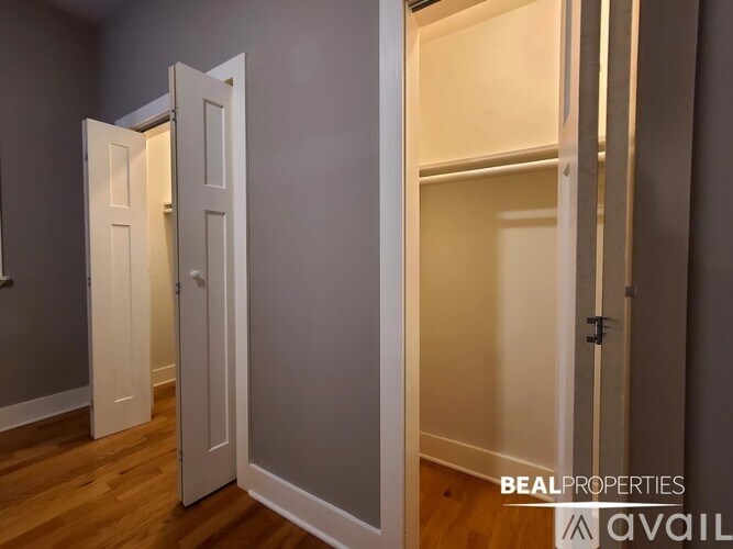 A BEALPROPERTIES AVAIL sign is on the wall of a room with a white door.