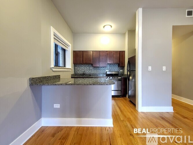 A kitchen with a granite countertop and wooden cabinets.