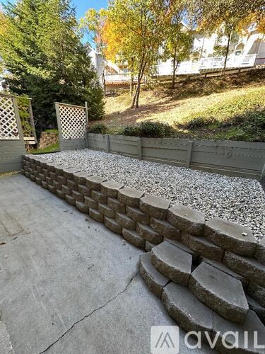 A concrete retaining wall with a gravel path in front of it.
