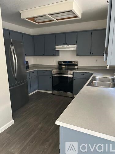 A kitchen with a stainless steel refrigerator and a stainless steel sink.