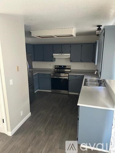A kitchen with a stove, oven, and sink.