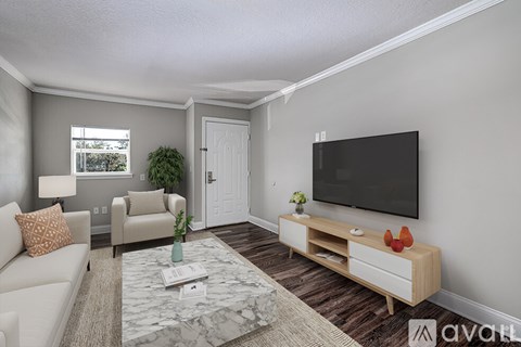 A living room with a couch, chair, and a television.