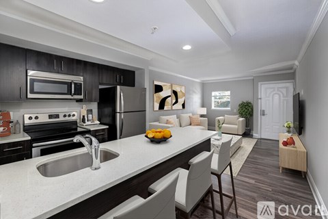 A modern kitchen with a dining area in the background.