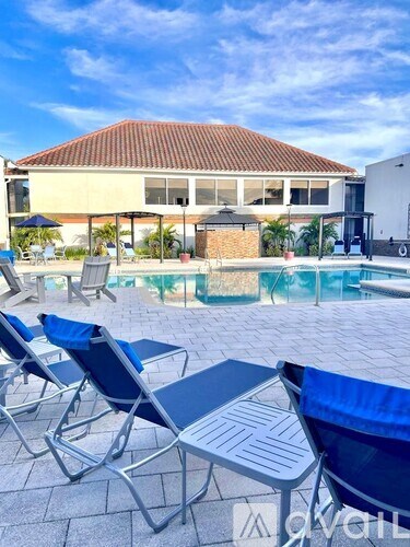 A poolside area with chairs and a table.