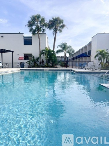A pool with a clear blue water and a building in the background.