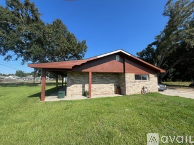 A house with a red roof and a green lawn in front.