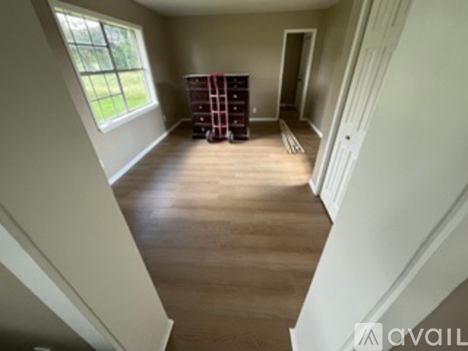 A room with wooden floors and a large window.