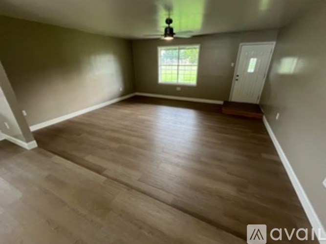 A room with wooden flooring and a window.