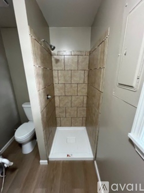 A small bathroom with a toilet and a walk in shower.